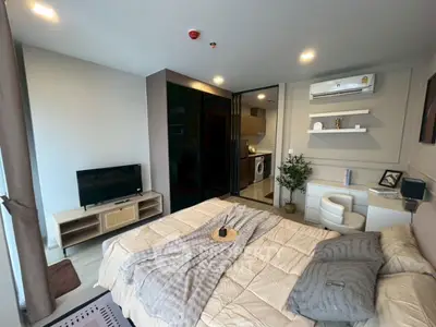 Modern bedroom with cozy decor and open layout featuring TV and air conditioning.
