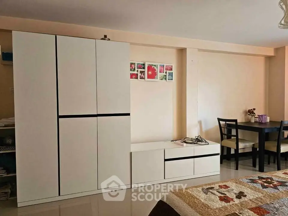 Cozy living room with modern white furniture and dining area, perfect for small apartments.