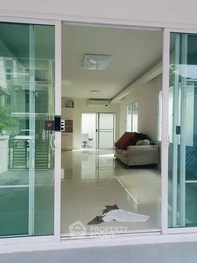 Spacious modern living room with glass sliding doors and sleek interior design.