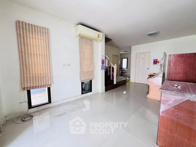 Spacious living room with modern air conditioning and sleek tile flooring