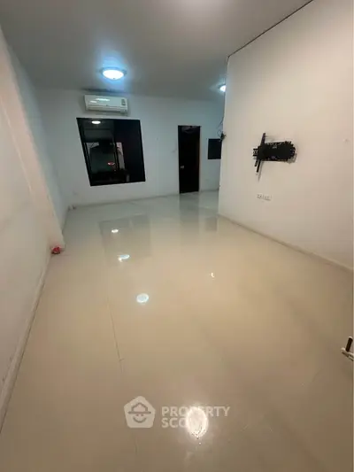 Spacious empty room with air conditioning and wall mount, ideal for customization.