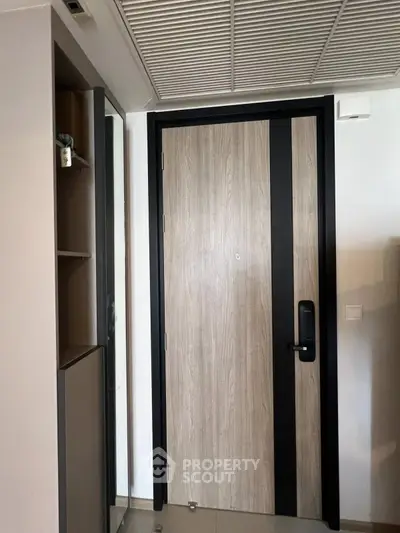 Modern apartment entrance with sleek wooden door and digital lock