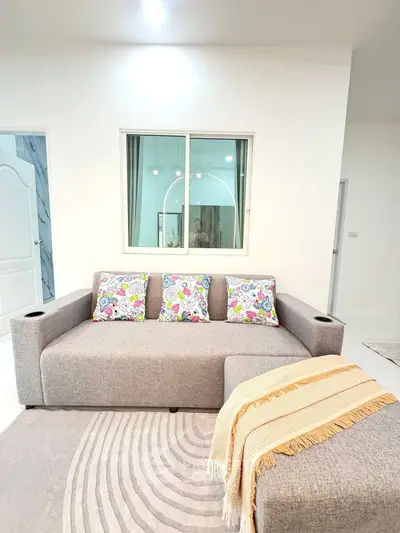 Modern living room with stylish gray sofa and colorful cushions, perfect for cozy relaxation.