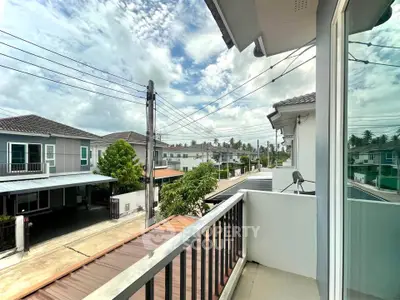 Charming suburban balcony view with modern houses and lush greenery.