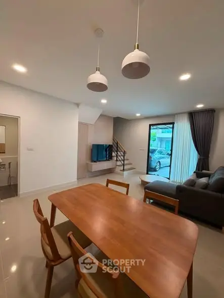 Modern open-plan living room with dining area and large window view