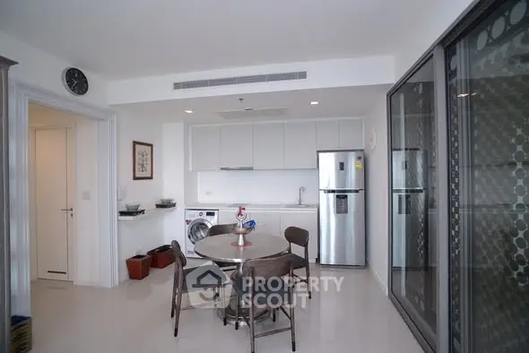 Modern kitchen with dining area, sleek appliances, and stylish decor in a contemporary apartment.