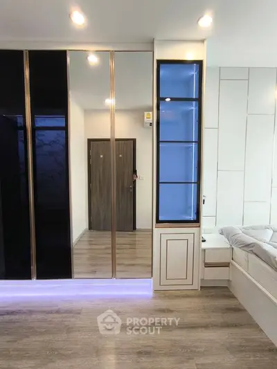 Modern bedroom with sleek mirrored wardrobe and elegant wood flooring