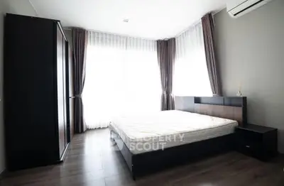 Modern bedroom with sleek furniture and large windows for natural light