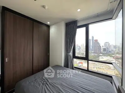 Modern bedroom with city view and large windows in high-rise apartment