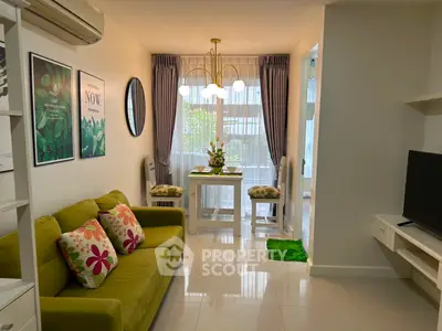 Charming living room with green sofa, modern decor, and natural light in cozy apartment.