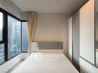 Modern bedroom with large windows and sleek wardrobe in urban apartment