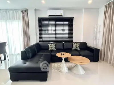 Modern living room with sleek black sofa and stylish coffee tables