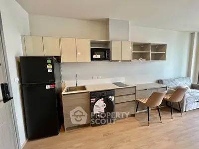 Modern kitchen with sleek cabinetry, integrated appliances, and cozy dining area in open-plan living space.