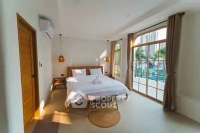 Spacious bedroom with large windows offering stunning city views and modern decor.