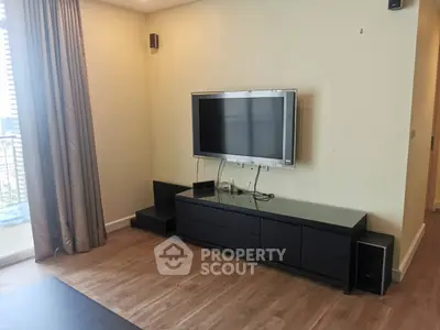 Modern living room with sleek TV setup and balcony view