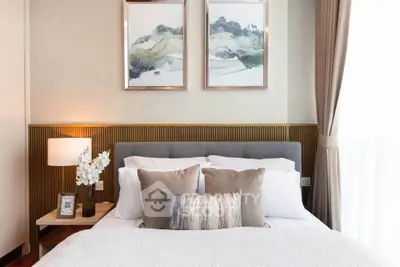 Elegant bedroom with stylish decor and natural light, featuring a cozy bed and modern artwork.