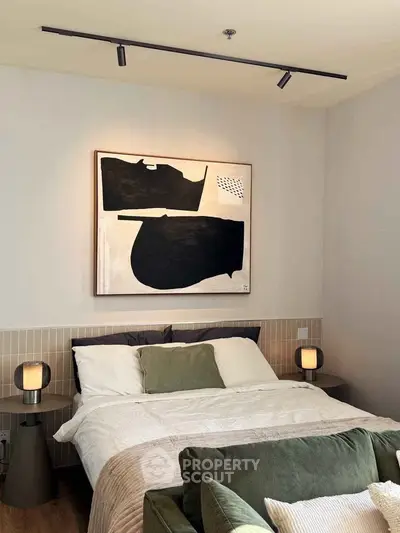 Stylish bedroom with modern art and cozy lighting in a contemporary apartment.