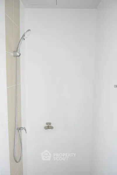 Minimalist shower area with sleek fixtures in modern bathroom.