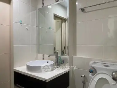 Modern bathroom with sleek sink and toilet in a contemporary apartment.