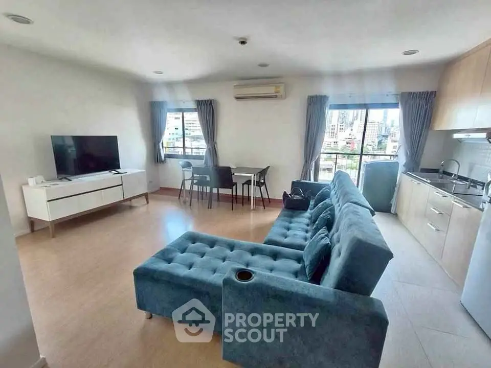 Spacious living room with modern furniture and city view, perfect for urban living.