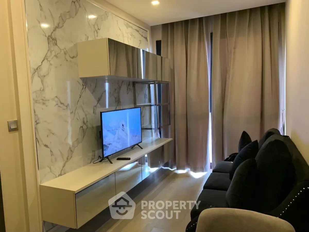 Modern living room with sleek marble wall and stylish shelving, featuring a cozy seating area and flat-screen TV.