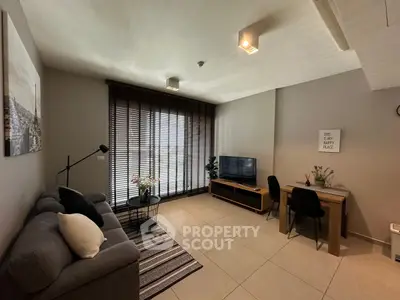 Modern living room with stylish decor, large window, and cozy seating area.