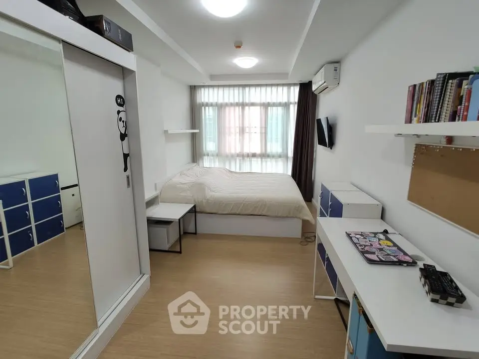 Modern bedroom with minimalist design, featuring a cozy bed, ample storage, and natural light from large window.