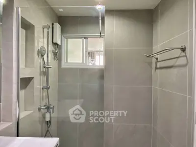 Modern bathroom with sleek shower and neutral tiles, perfect for a contemporary home.