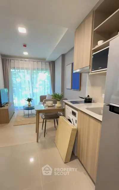 Modern open-plan kitchen and living room with stylish decor and natural light.