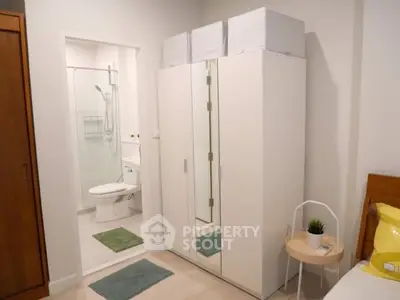 Modern bedroom with ensuite bathroom and sleek white wardrobe