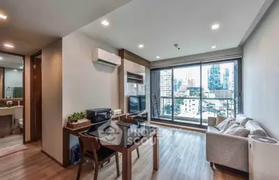 Modern living room with city view, featuring sleek furniture and large windows for natural light.
