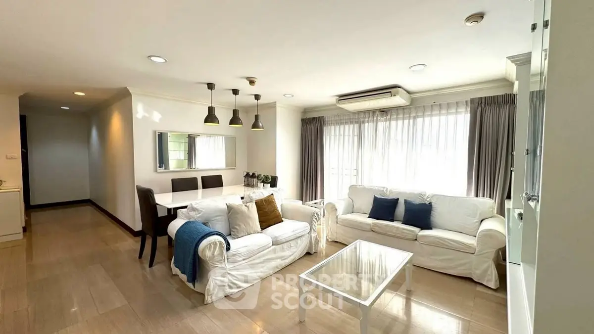 Spacious living room with elegant decor and ample natural light, perfect for relaxation and entertaining.