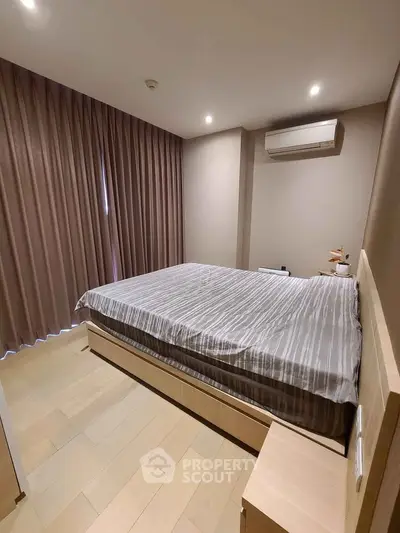 Modern bedroom with stylish decor and air conditioning in a cozy apartment.