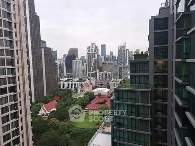 Stunning cityscape view from high-rise building with lush greenery and modern architecture.