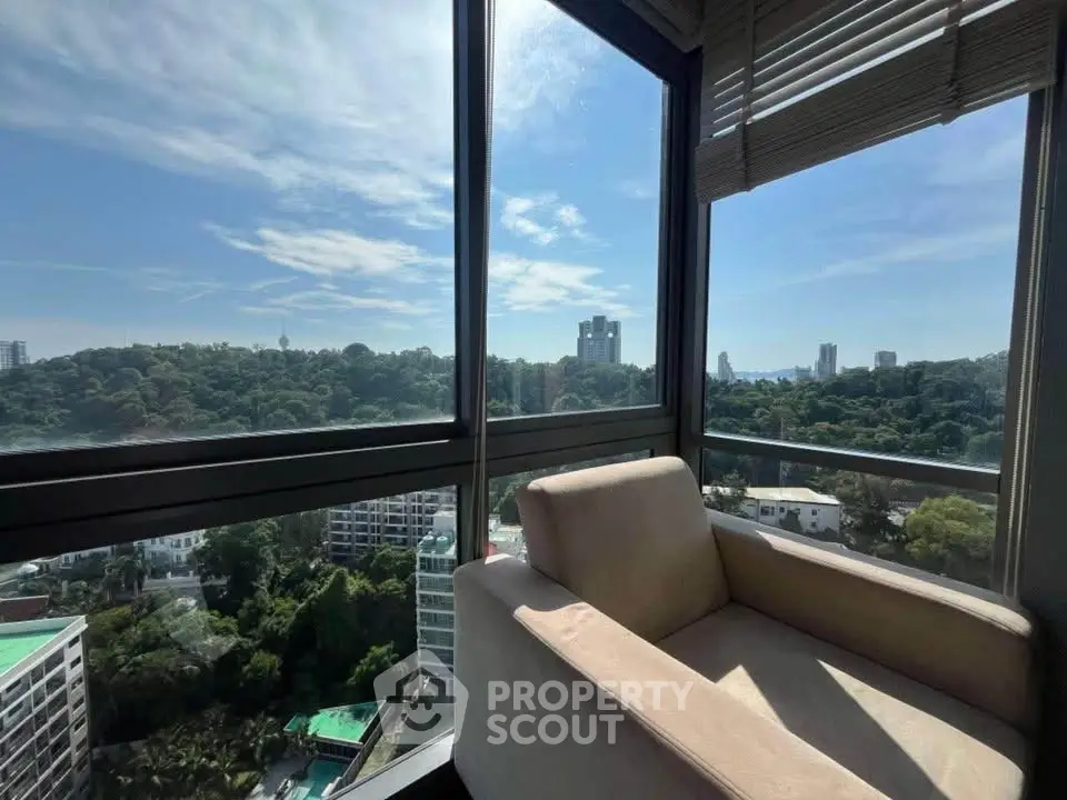 Stunning high-rise apartment with panoramic city views and cozy seating area.