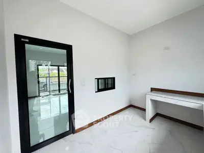 Modern interior with sleek sliding glass door and marble desk, perfect for a stylish home office.
