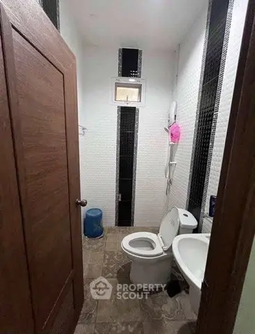 Compact bathroom with modern fixtures and tiled walls