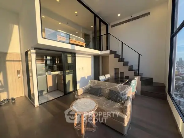 Modern duplex apartment with large windows and stylish interior design.