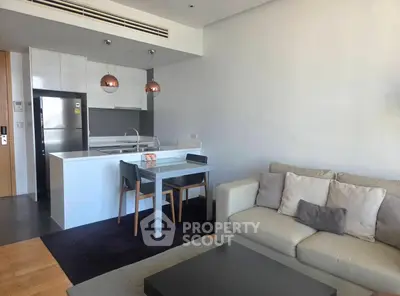 Modern open-layout living room with sleek kitchen and cozy dining area.