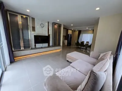Spacious modern living room with elegant furniture and open dining area, perfect for family gatherings.
