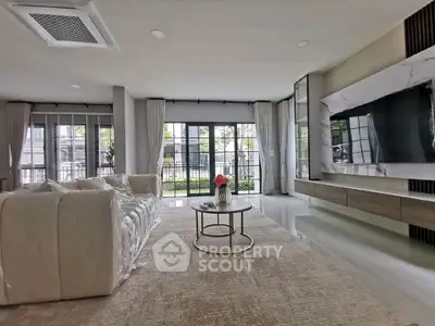 Spacious modern living room with large windows and elegant decor