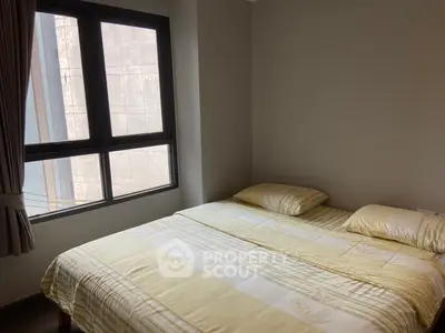 Cozy bedroom with large window and soft lighting, perfect for relaxation.