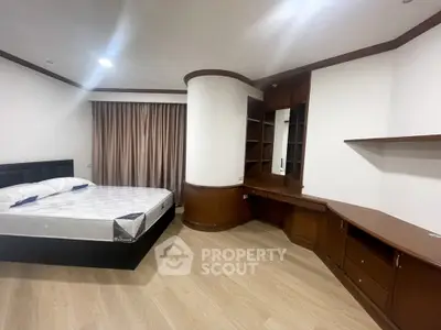 Spacious bedroom with elegant woodwork, ample storage, and modern flooring, ideal for luxurious living in a prime location.