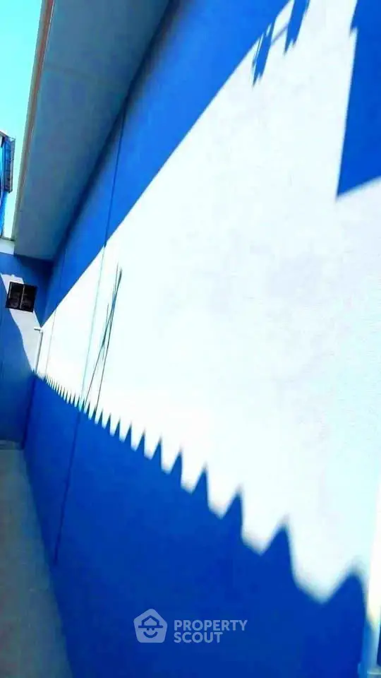 Striking blue and white exterior wall with unique geometric shadow pattern
