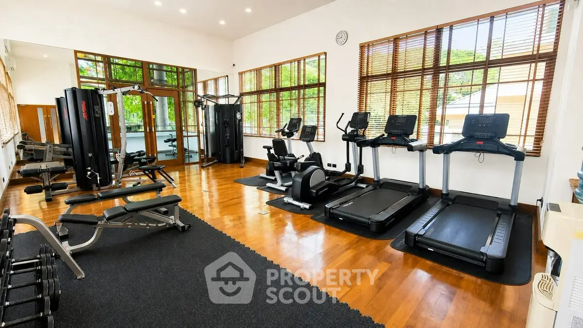 Spacious and well-equipped gym with modern fitness machines and large windows.