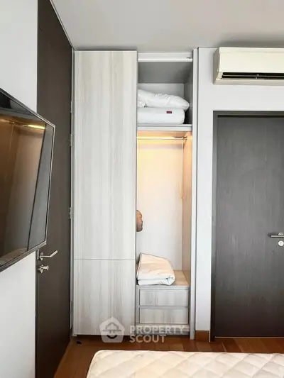 Modern bedroom with built-in wardrobe and air conditioning unit