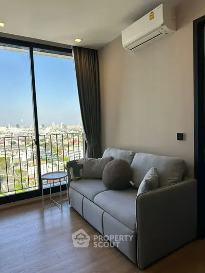 Modern living room with city view and cozy sofa in high-rise apartment.