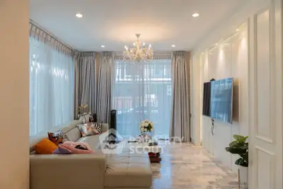 Elegant living room with chandelier, large windows, and modern decor