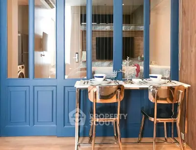 Stylish dining area with blue partition and modern decor in a contemporary apartment.