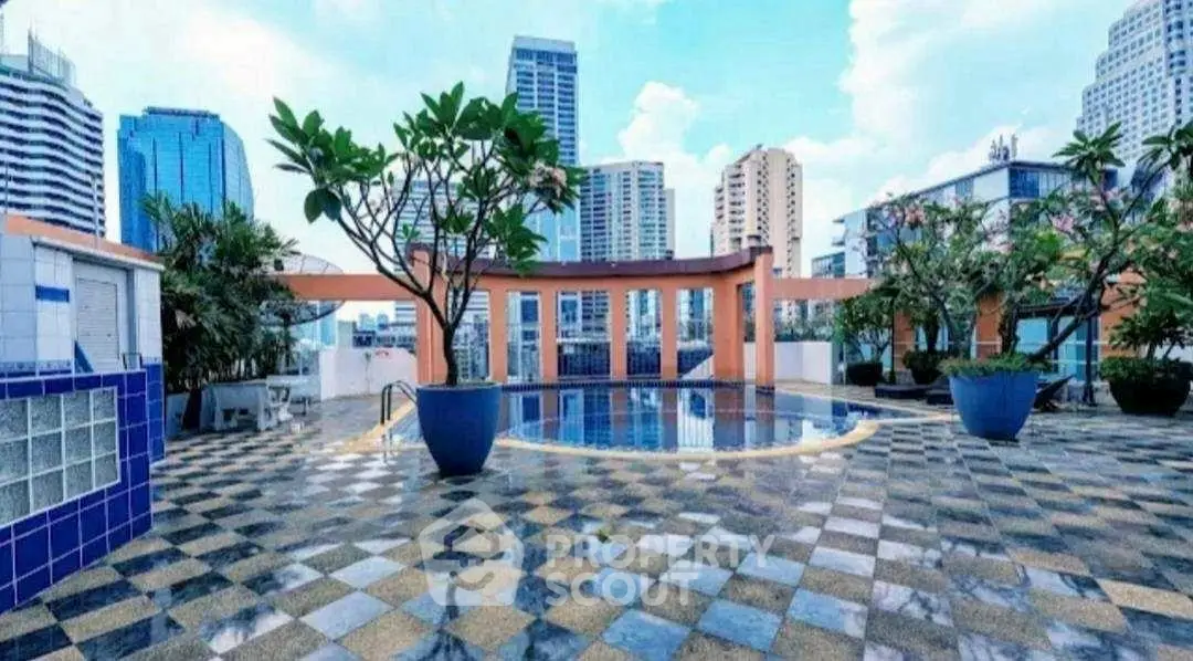 Stunning rooftop pool with city skyline views and elegant tile flooring.